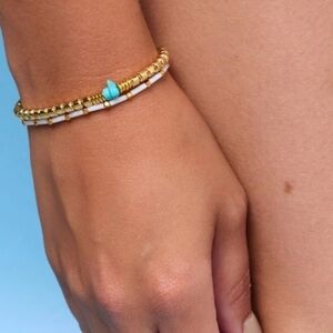 Pair of stretchy gold tone Pura Vida bracelets